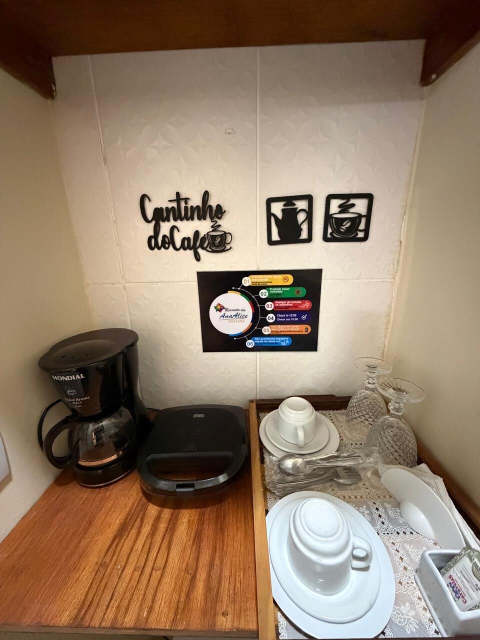 Angolo cottura con una macchina per il caffè, un bollitore e una tazza di caffè su un tavolo.