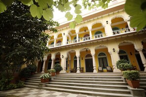 A building with multiple arches, a balcony, and steps leading to the entrance. - Narain Niwas Palace (Jaipur)