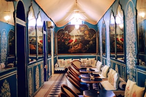 Un restaurante con un mural, cabinas y piso a cuadros.