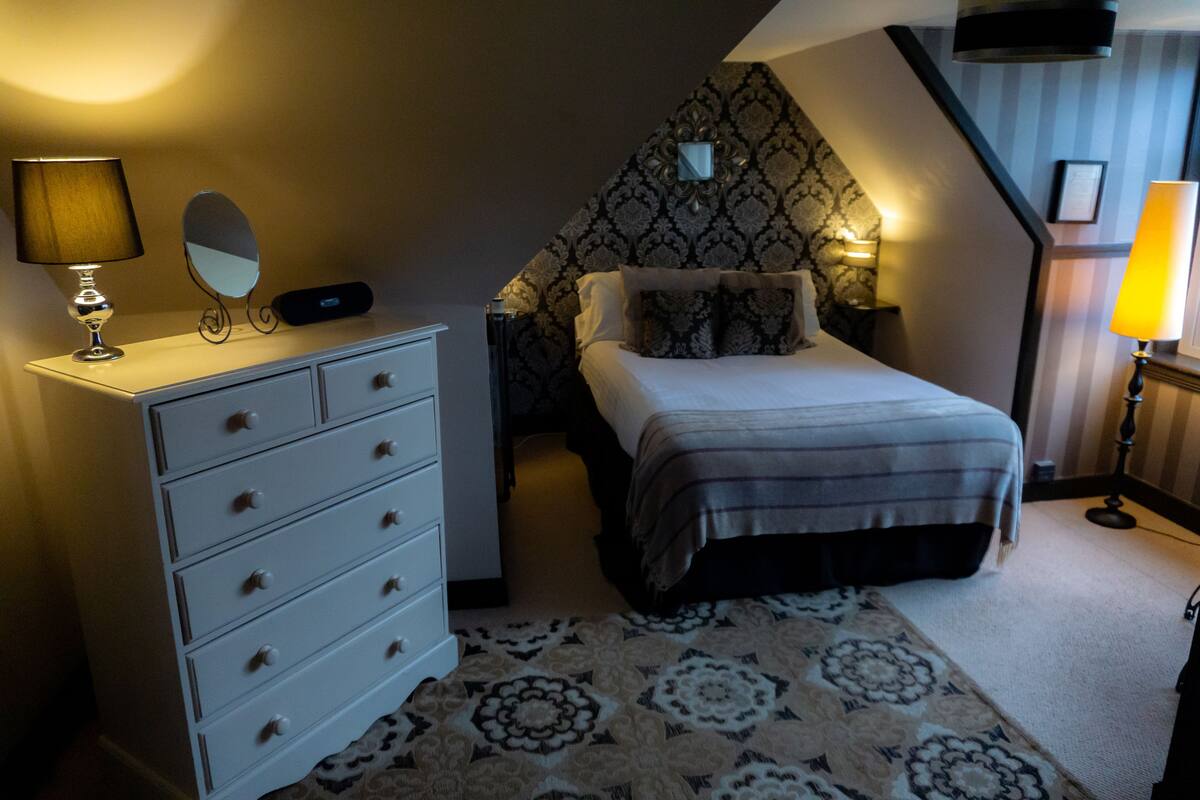 Ein Schlafzimmer mit Bett, Schminktisch und Lampen.