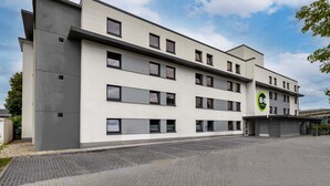 A modern hotel building with a flat roof, multiple windows, and a parking area. - B&B HOTEL Koblenz-City (Koblenz)