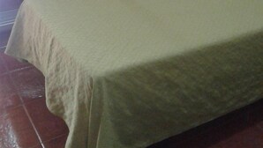 Una habitación con una cama individual, una puerta corredera y un armario pequeño.