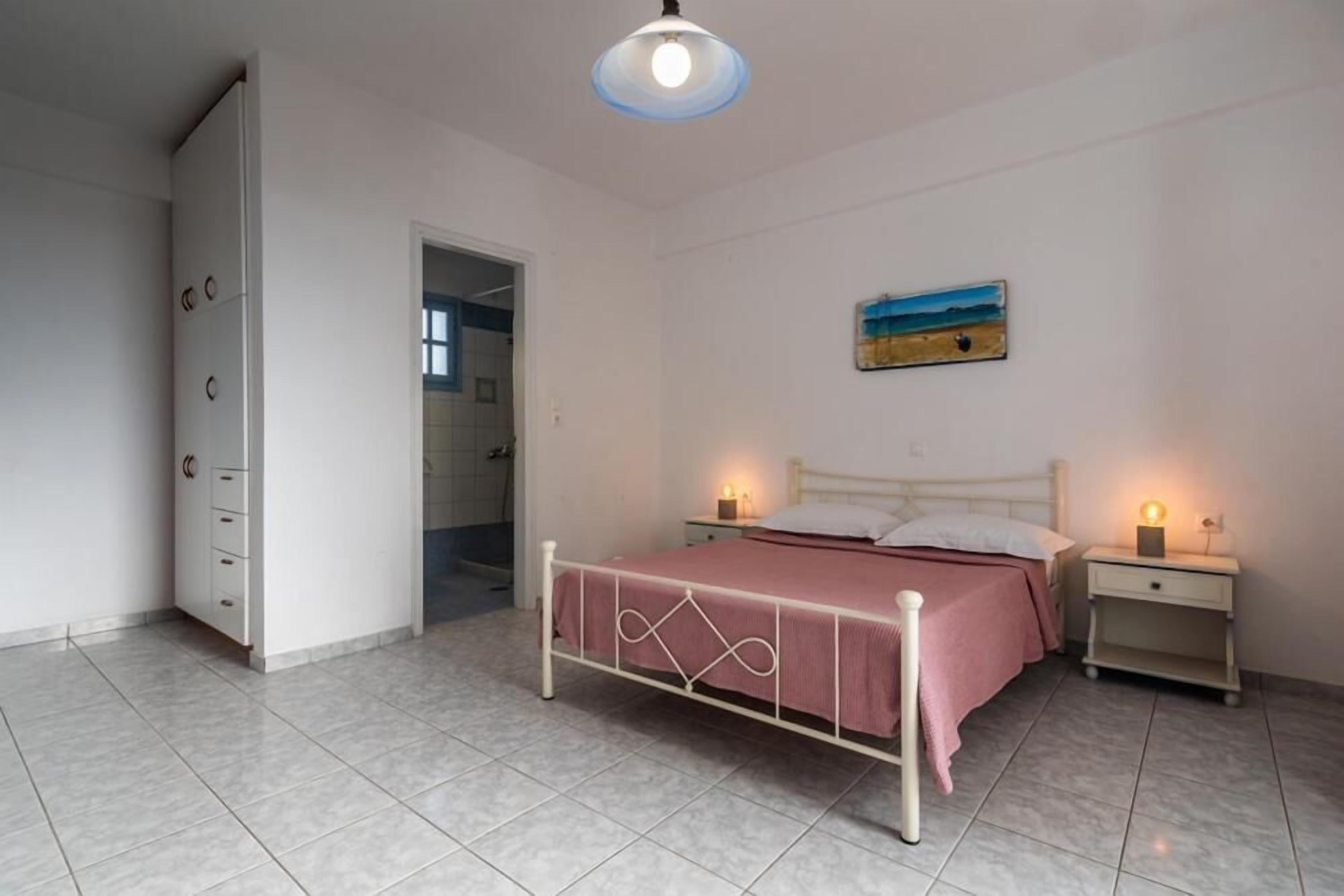 Ein Schlafzimmer mit einem Bett, Nachttischen, einem Kleiderschrank und einem Bild an der Wand.
