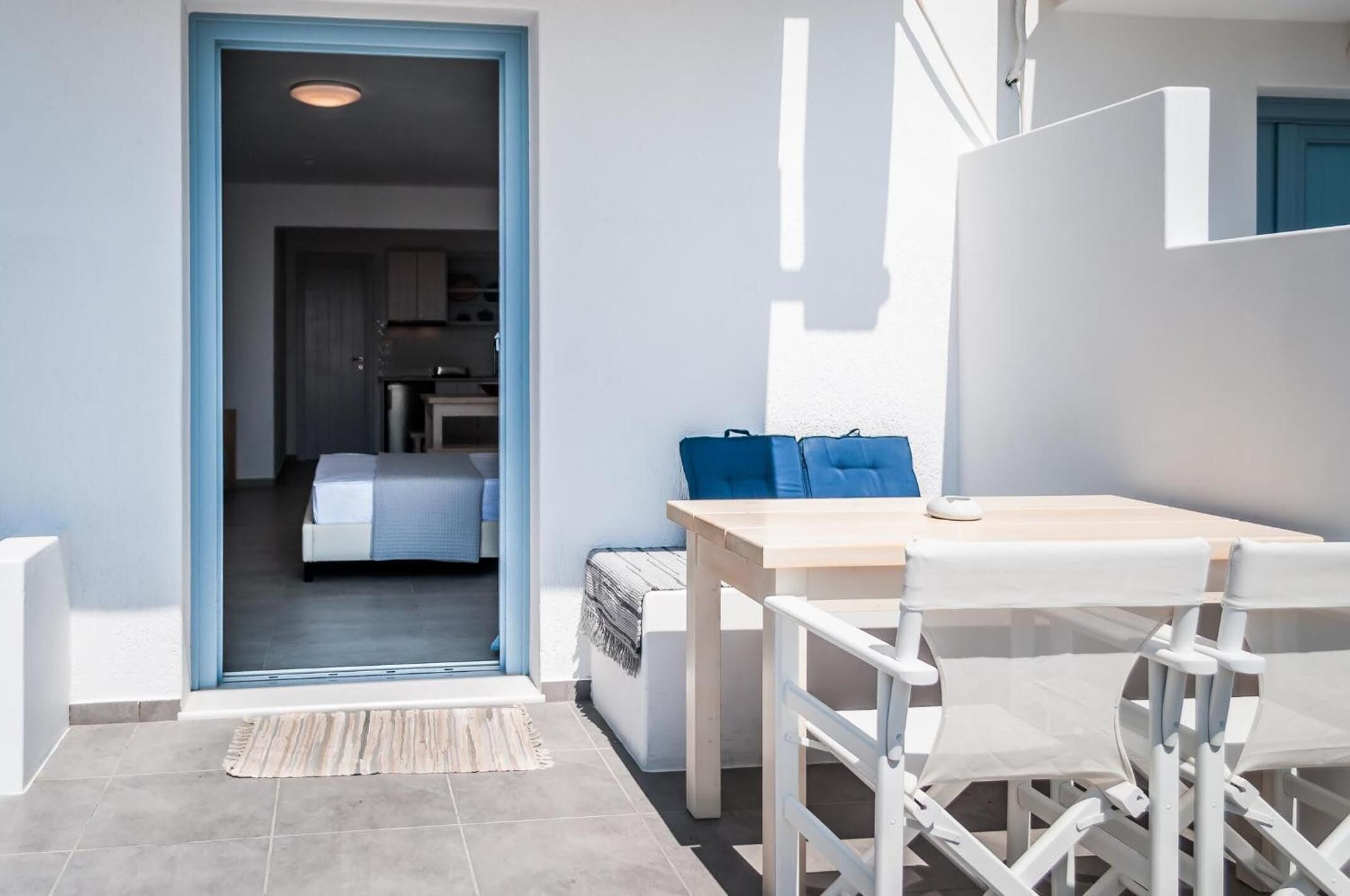 Una habitación moderna y bien iluminada con una cama, una mesita y sillas.