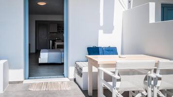 Una habitación moderna y bien iluminada con una cama, una mesita y sillas.