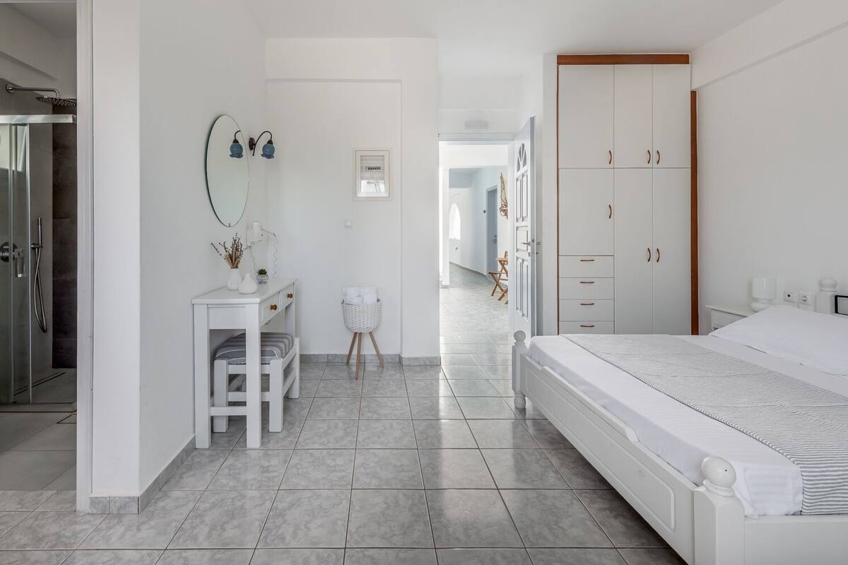 Um quarto moderno com uma cama grande, uma escrivaninha e um closet espaçoso.