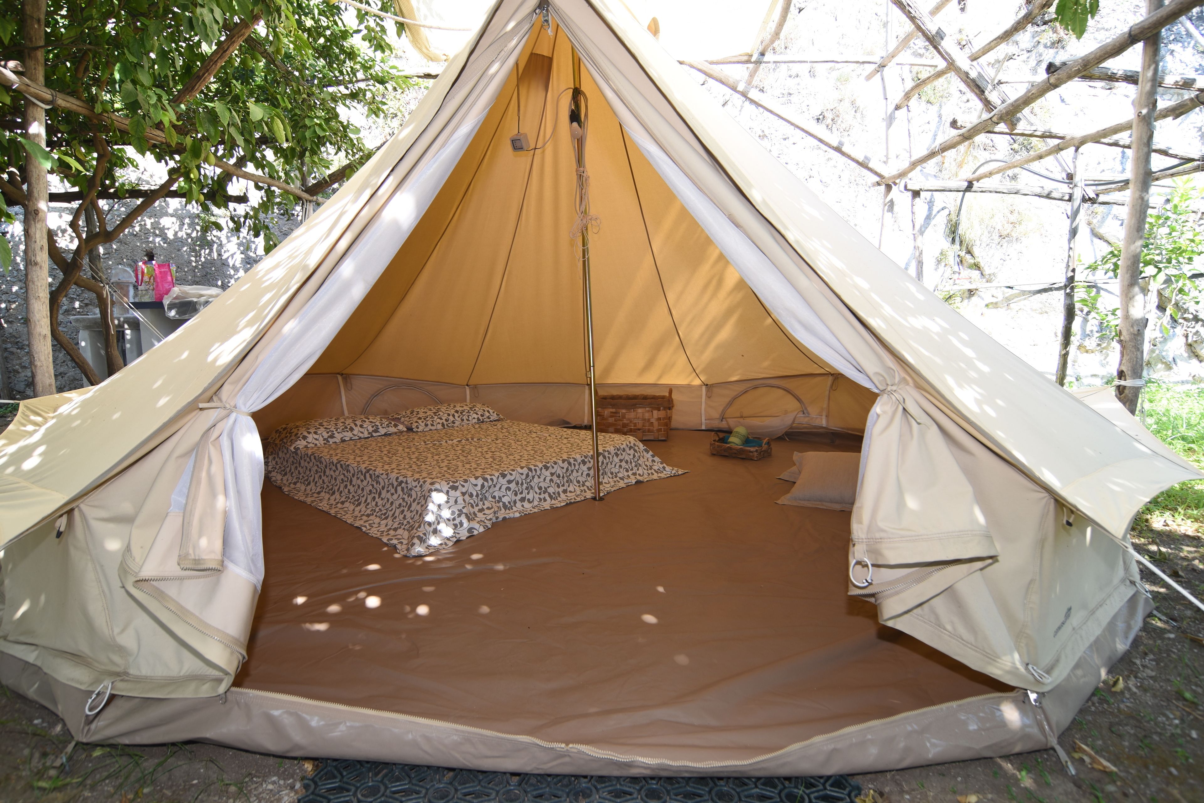 A tent with a sleeping area, a small table, and a hanging bag.