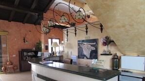 Un espace d’accueil avec un comptoir, une carte affichée au mur et un panneau indiquant « LLAVES KEYS ».