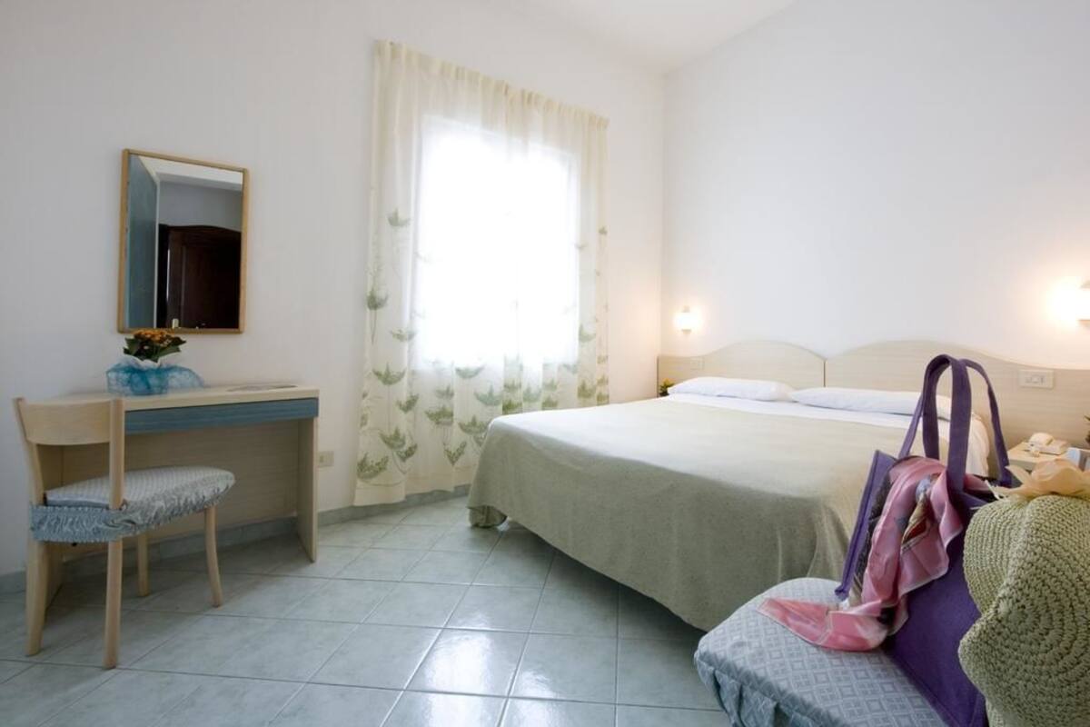 Un dormitorio con cama, escritorio y silla.