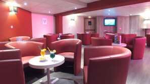 A modern lounge area with red leather chairs and a small table with drinks. - Vvf Villages Sare (Sare)