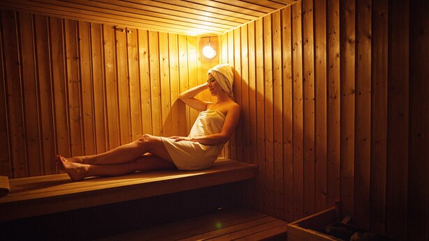 Una sauna de madera con bancos y un asiento.