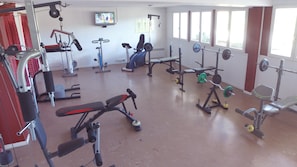 A gym with various exercise equipment, a television mounted on the wall, and large windows. - Vvf Villages Sare (Sare)