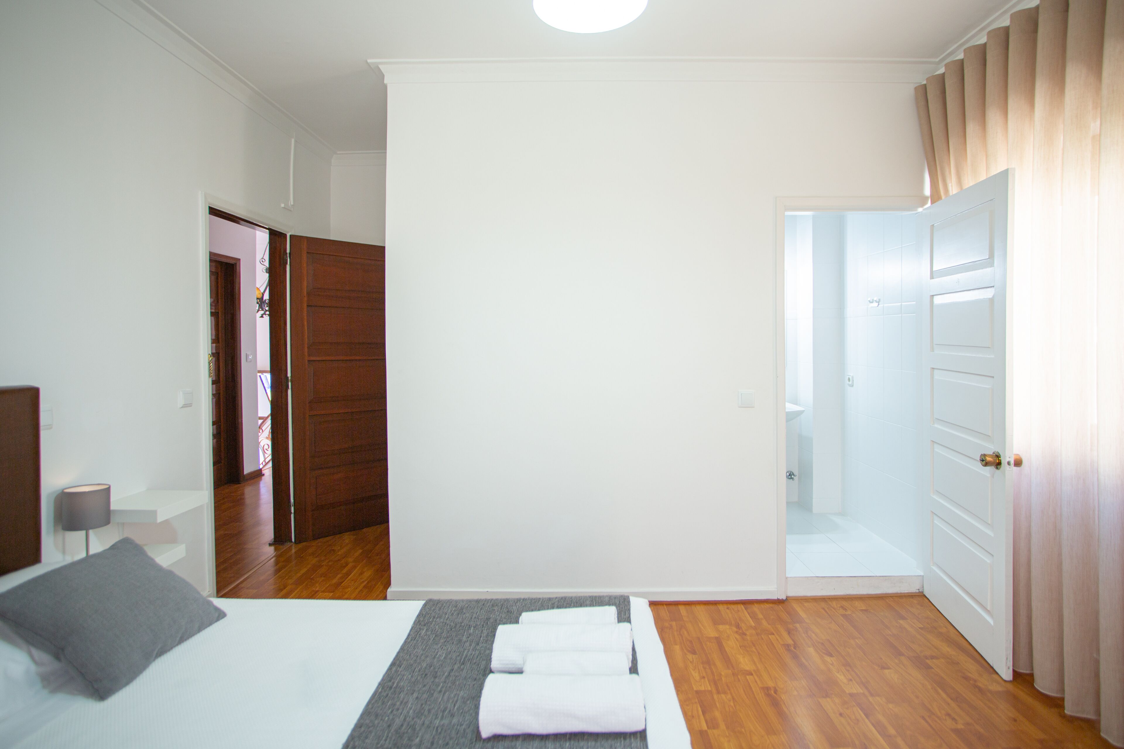 Une chambre à coucher avec un lit, une table de chevet et une porte en bois.