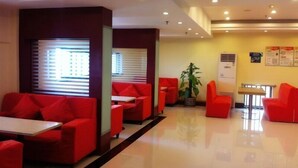A modern lobby with red seating, a potted plant, and a reception desk. - GreenTree Inn Suzhou Mudu Ancient Street Express Hotel (Suzhou)
