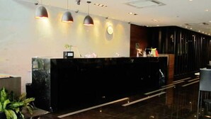 A modern reception desk with a dark marble top, three pendant lights, and a clock on the wall. - Bangkok City Hotel (Bangkok)