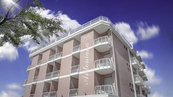 Ein mehrstöckiges Hotel mit Balkonen und einem wolkenlosen Himmel.