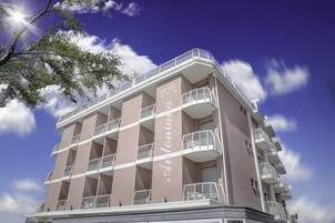 Un hotel de varios pisos con balcones y un cielo despejado.