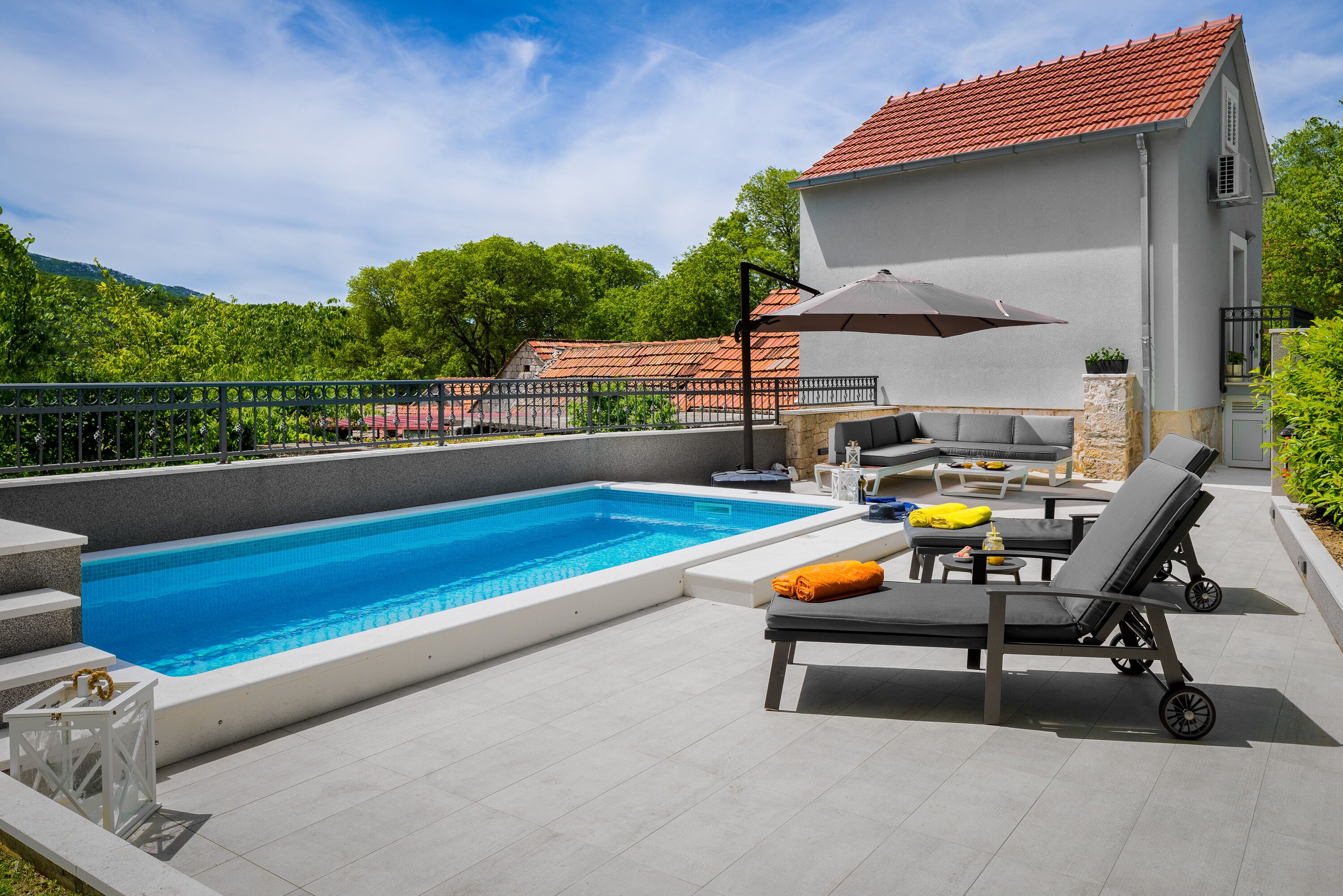 A swimming pool with lounge chairs and a barbecue area.