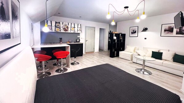 Un appartement moderne comprenant une cuisine, un coin repas et un salon.