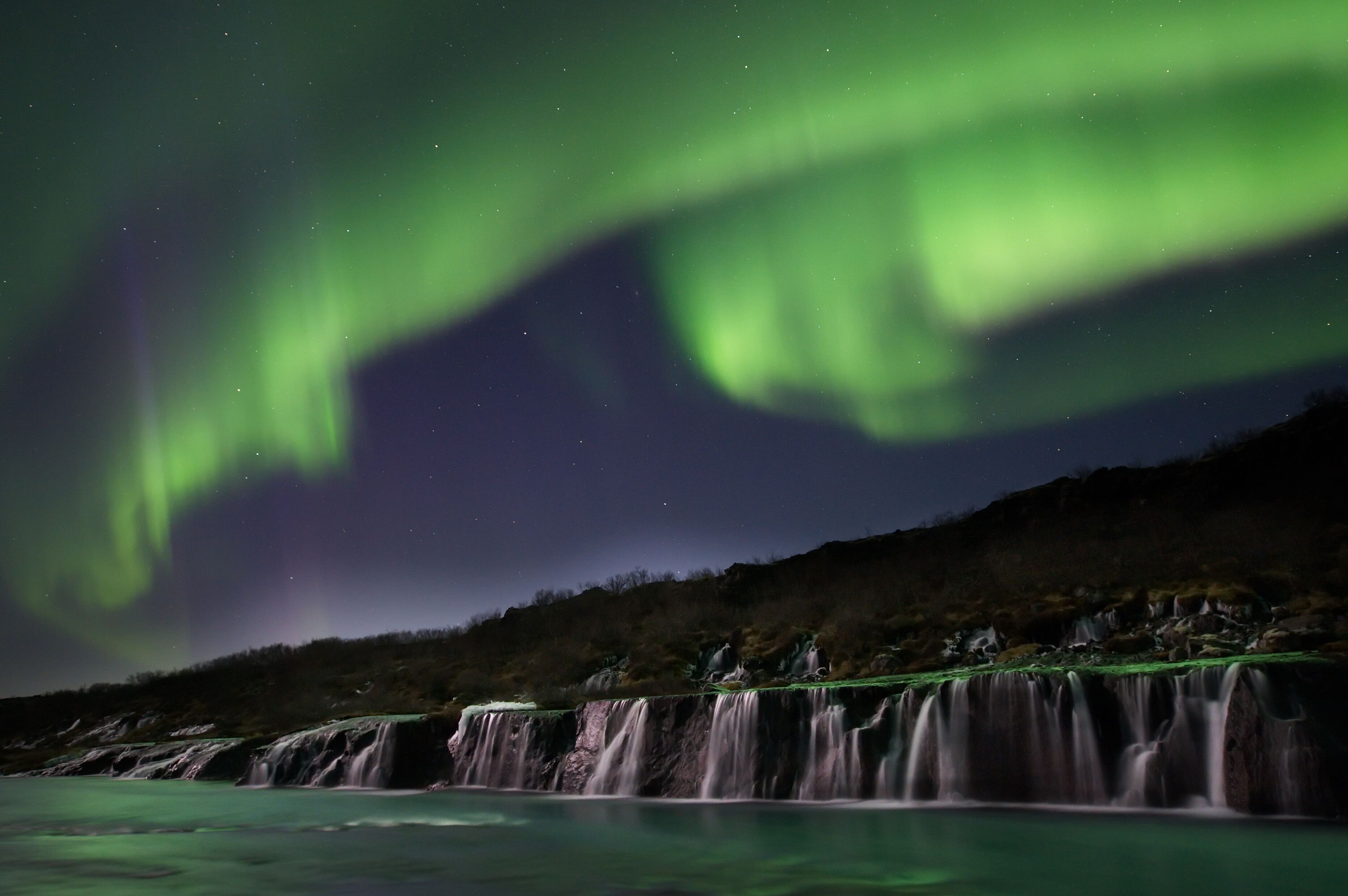 Una cascata con vista sul cielo notturno.