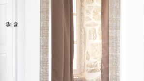 A mirror with a brown curtain partially drawn, reflecting a stone wall and a window. - Charming stone house in Cavtat old town (Cavtat)