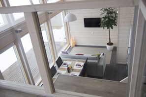 A modern dining area with a table set for two, a potted plant, and a flat-screen TV on the wall. - Beautiful mini villa right on the lakeside (Uro)