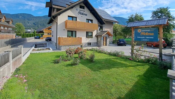 Un immeuble de deux étages avec une enseigne indiquant « apartmanji Helena » et « Dobrodosli / Bienvenue ».