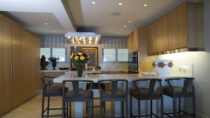 Une cuisine moderne dotée d’un îlot central, de tabourets de bar et d’un vase décoratif.