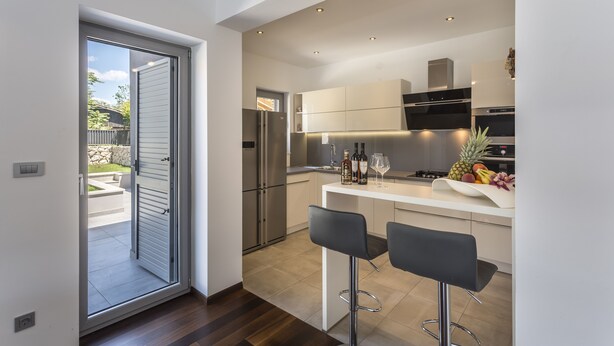 A modern kitchen with a large island, stainless steel appliances, and a view to the outside. - Beautiful Eco-Friendly Villa in Split – Just Steps from Marjan and the Center (Split)