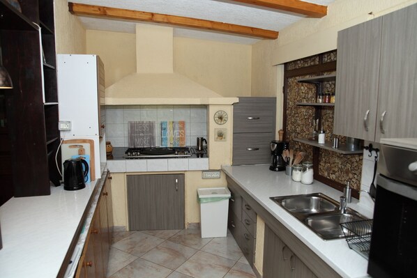 A compact kitchen with a gas stove, a coffee maker, and a sink. - Under the Walnut Tree Pomer - Family & pet-friendly, big lawn, greenery, nature (Pomer)