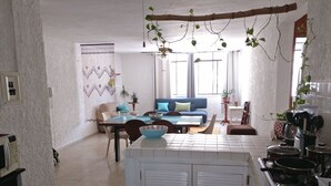A spacious living area with a dining table, a sofa, and a kitchen area with a stove and pots. - Clean spacious apartment w/ pool. Central Cancun 5 mins from beach (Cancún)