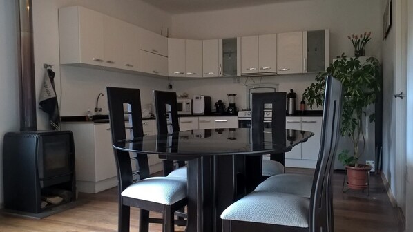 A modern kitchen with white cabinets, a black dining table, and four chairs.