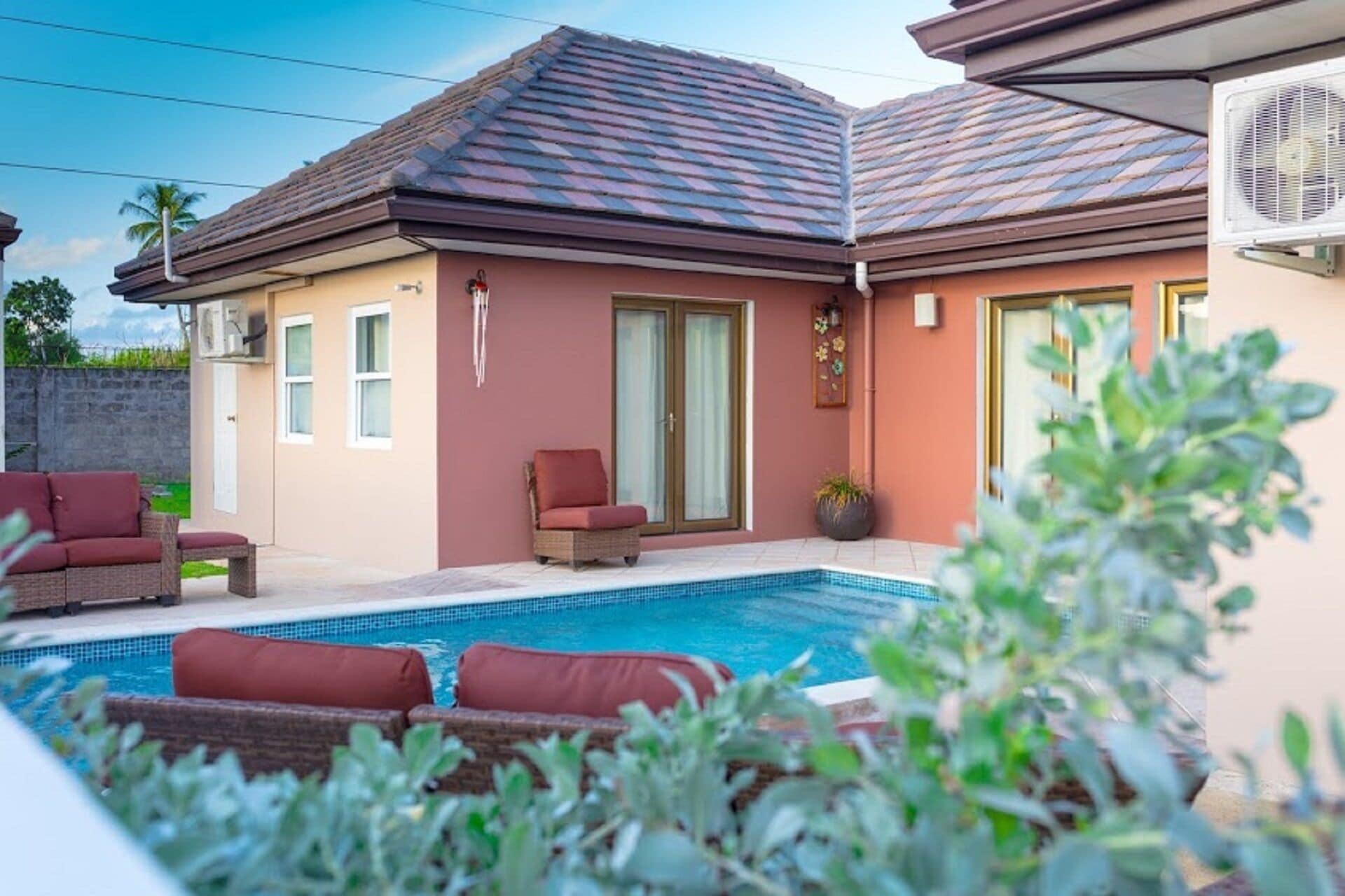 A house with a swimming pool, a covered patio, and a fan.