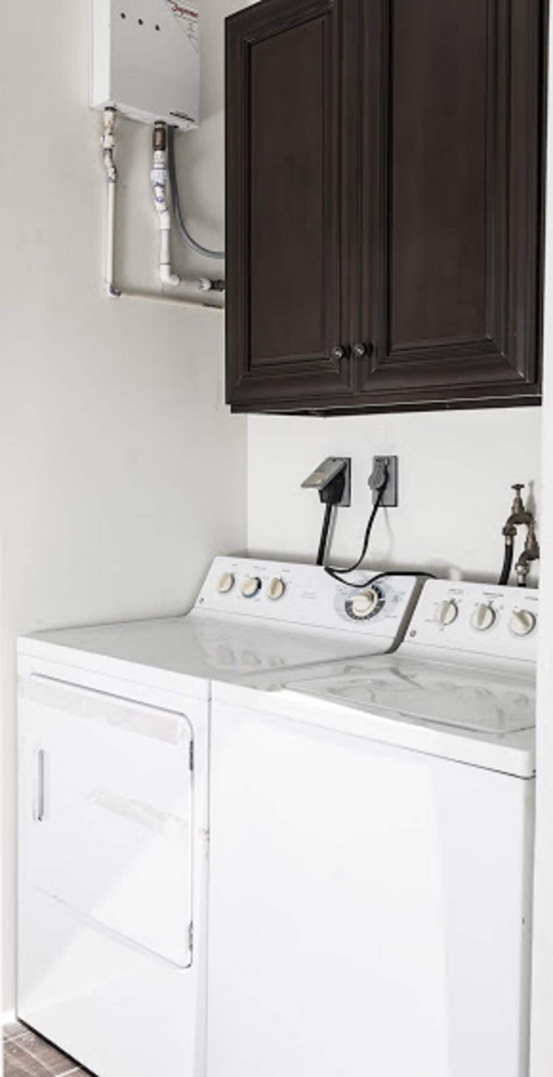 A laundry area with a washing machine, a dryer, and a water heater.