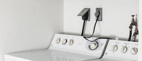 A laundry area with a washing machine, a dryer, and a water heater.
