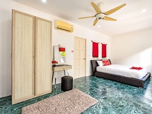 A bedroom with a bed, a wardrobe, a desk with a mirror, and a ceiling fan.