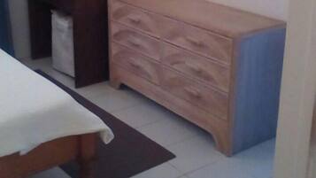 Une chambre à coucher avec un lit, une commode et une armoire.