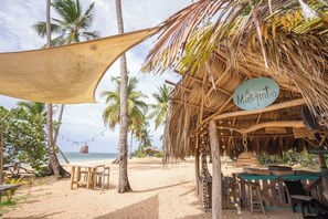 A beachside hut named "El Mosquito" with a thatched roof, wooden furniture, and star decorations. - Beautiful Beach Condo vacation rental in Las Terrenas in Balcones del Atlántico. (Las Terrenas)