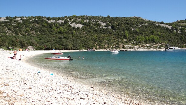 A beach with clear water, boats, and a hilly backdrop. - Traditional Istrian stone villa – 'Villa Ane' - Rakalj (Rakalj)