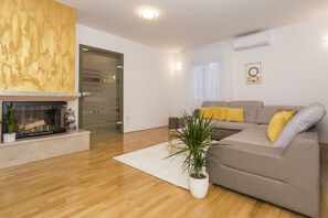 Un salon moderne avec une cheminée, un canapé avec des coussins jaunes et une plante en pot.