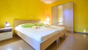 Une chambre à coucher avec un lit, des tables de chevet, une armoire et une lampe.