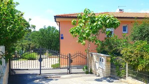 Ein Gebäude mit rotem Ziegeldach, einem verschlossenen Eingang und einem Baum davor.
