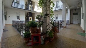 A multi-level atrium with potted plants, a staircase, and balconies.