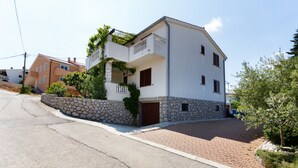 A two-story building with a stone facade, a brown door, and a small balcony. - JP2 - studio-apartment for 2 person (Vrbnik)