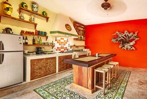 Enjoy cooking in this kitchen with a red accent wall, wooden island, and ample kitchenware.
