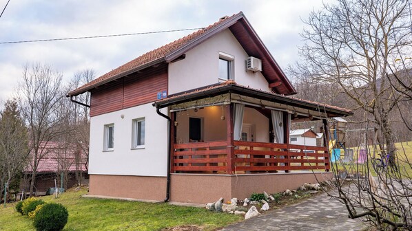 A two-story house with a balcony, a small porch, and a visible window. - D.I.M. Holiday House Plitvice Lakes (RAKOVICA)
