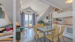 A modern apartment with a dining area, kitchen, and a balcony with a view. - Beautifull attic over the sea and river coust, panoramic sea view (Omiš)
