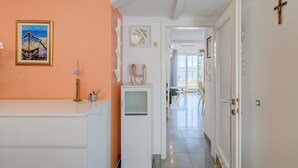 A hallway with a white door, a cross on the wall, and a painting of a boat. - Beautifull attic over the sea and river coust, panoramic sea view (Omiš)