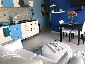 Una cucina moderna con piano cottura a gas, macchina da caffè e un piano di lavoro blu.