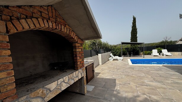 An outdoor patio with a stone fireplace, a swimming pool, and lounge chairs. - Hidden Villa **** With Private Pool In Peaceful Area  (Vinišce)
